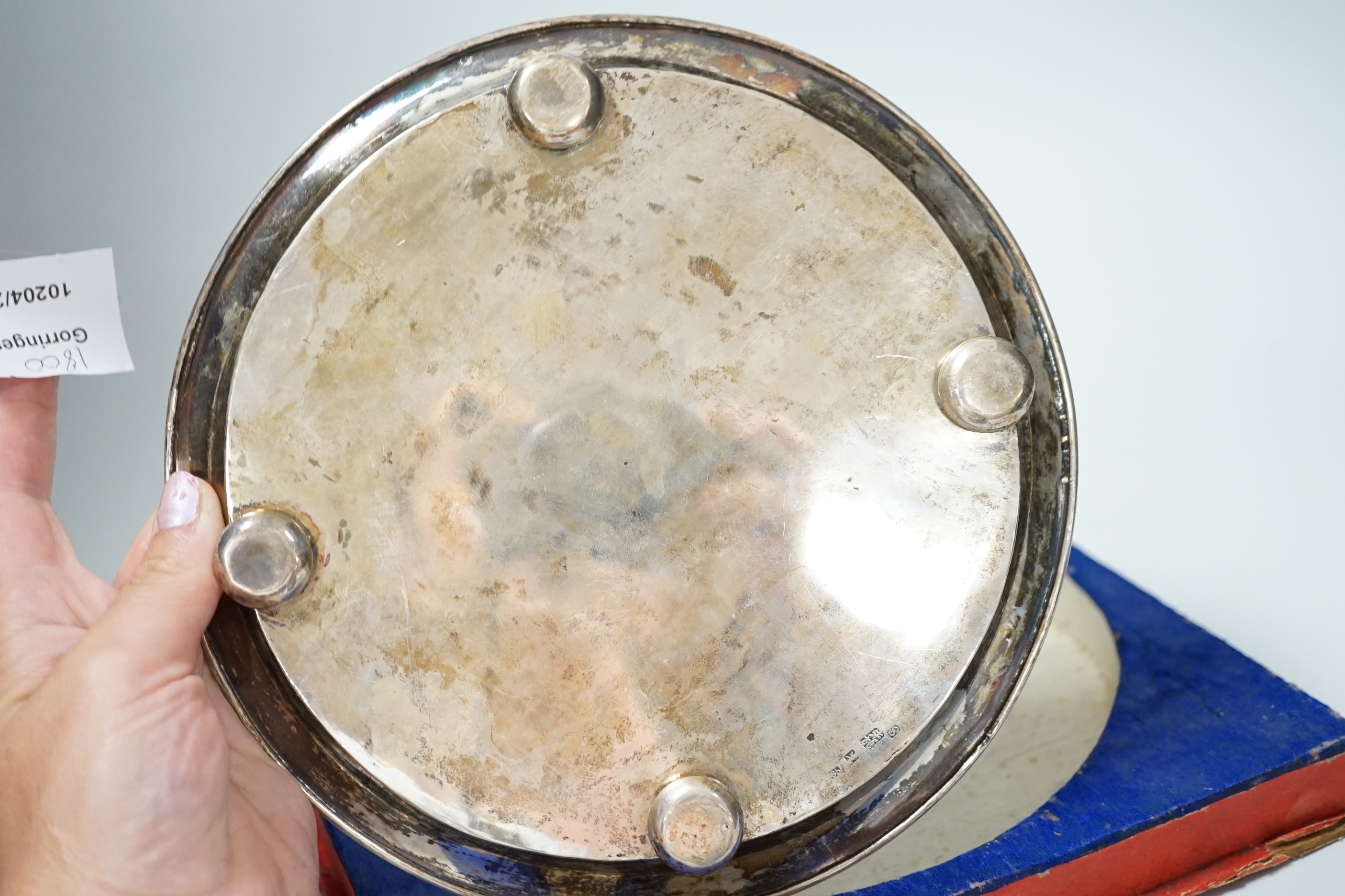 A Chinese white metal ‘dragon’ salver, late 19th century, 20.2cm carded silk box base and two similar napkin rings.